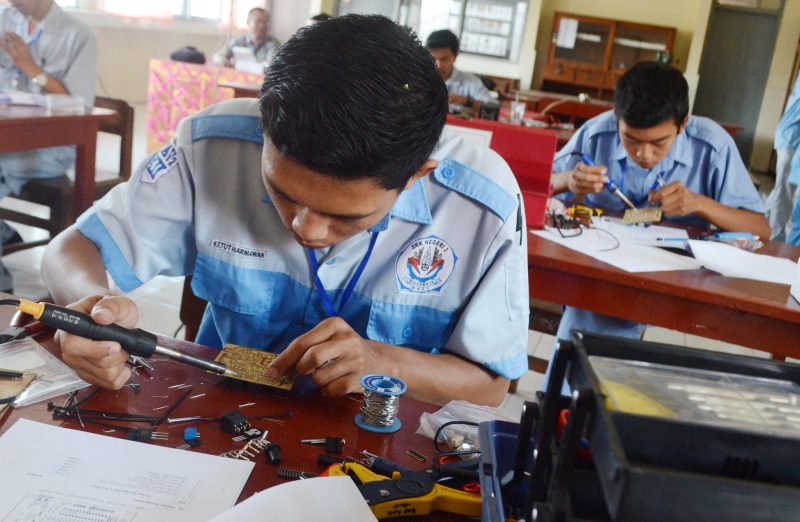 Pelajar Sekolah Menengah Kejuruan (SMK) memasang komponen elektronik saat mengikuti Lomba Kompetensi Sekolah (LKS) antar pelajar SMK tingkat Provinsi Bali di SMK Negeri 1 Denpasar, Kamis (18/9). Kegiatan yang terdiri dari berbagai macam ketrampilan seperti Otomotif, Teknologi, Mesin dan Multimedia digelar dengan tujuan sebagai sarana pelajar untuk mengasah kemampuan dan sebagai aplikasi ilmu ketrampilan pelajar SMK. ANTARA FOTO/Fikri Yusuf/nz/14
